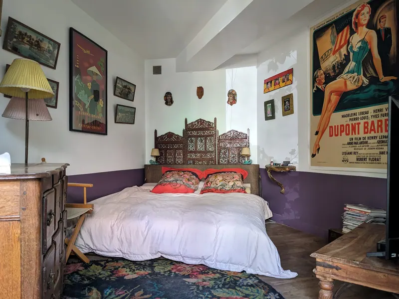 Bedroom with antique carved bed and large film poster