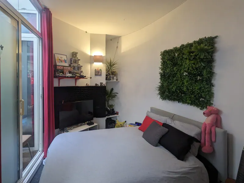 Bedroom with green wall and large glass door onto the patio