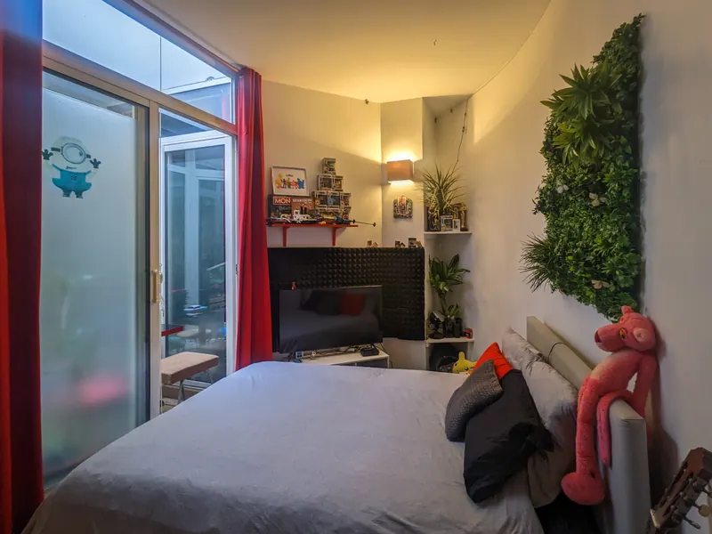 Chambre avec mur végétal et baie vitrée sur l'atrium
