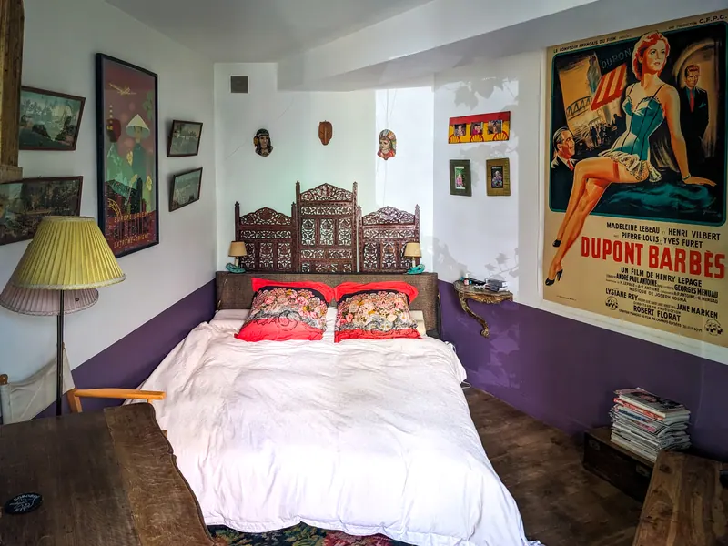 Chambre, tête de lit sculptée, murs blancs et prune