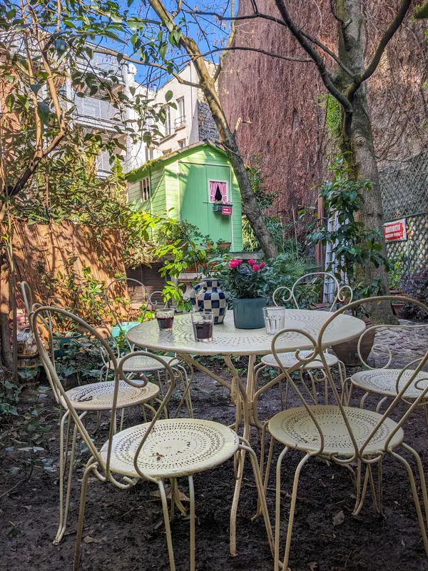 Salon de jardin en fer forgé sous les arbres