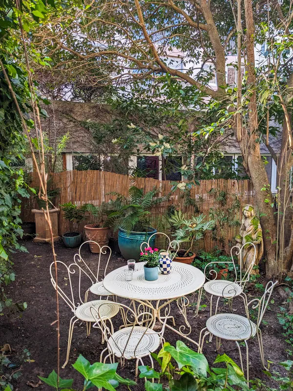 Coin repas du jardin entouré d'arbres