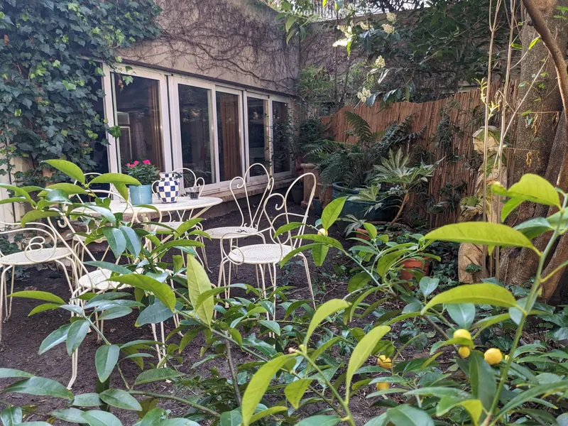 Garden terrace with wrought-iron tables facing the glass doors