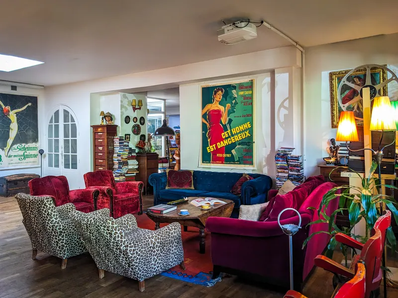 Séjour du loft avec affiches de cinéma et fauteuils en velours