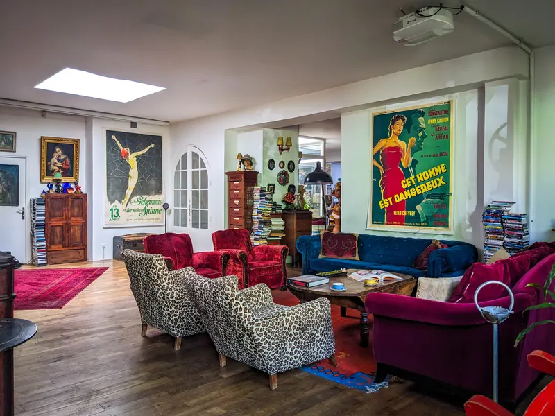 Grand séjour lumineux, parquet et affiches de cinéma anciennes